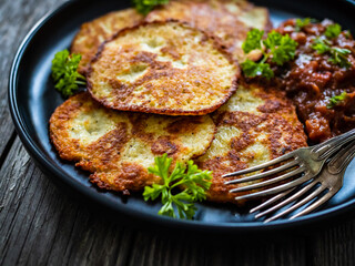 Potato pancakes with vegetable stew on wooden table
