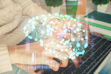 Double exposure of woman hands working on computer and brain hologram drawing. Ai concept.