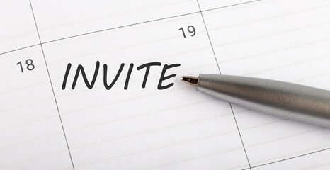 Text INVITE on calendar planner to remind you an important appointment with a pen on isolated white background.