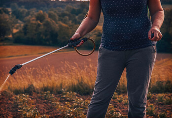 Woman gardening her garden. Spraying pesticide. © Kitja