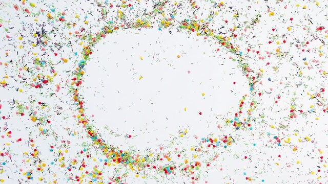 The hand makes a round frame for the inscription in the background of baking sprinkles. Time lapse video, 16x9 format. ProRes 422 HQ.