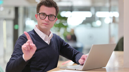 Serious Young Businessman with Laptop saying No with Finger Sign
