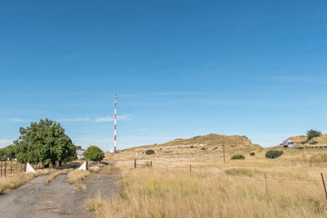 Obraz premium Cellphone tower, cattle grid, gate and truck, name Mooifontein visible