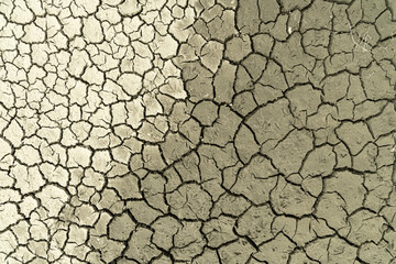 Mudflat cracked desert barren surface for natural background, layer, wallpaper, photo effect. Multicoloured drought effects of global warming