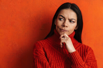 Young hispanic puzzled woman thinking and looking aside