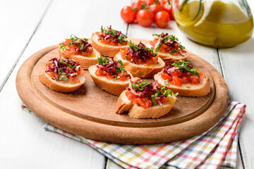 Deliziosi crostini vegetariani con pomodoro, rucola, radicchio e olio di oliva, cucina italiana 