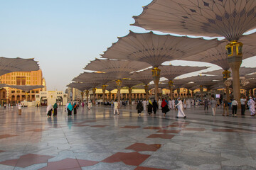 Muslim pilgrims walking at Nabawi Mosque. Courtyard view from Masjid Nabawi in Mecca city.
