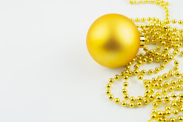 Christmas toys on a white background close-up, red, gold, yellow glass balls, gold beads, Christmas decorations on the Christmas tree