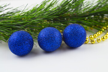 Christmas toys on a white background close-up, red, gold, yellow glass balls, gold beads, Christmas decorations on the Christmas tree