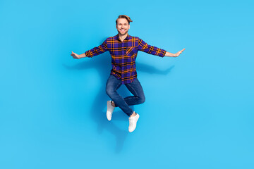 Fototapeta na wymiar Full length body size view of attractive cheerful funny guy jumping posing isolated over vivid blue color background