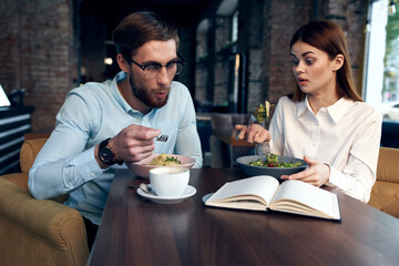 young couple in a cafe sitting at the table breakfast communication rest
