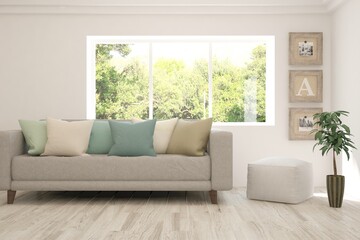 White living room with sofa and summer landscape in window. Scandinavian interior design. 3D illustration