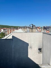 Rooftop of a white building in a city with clear sky