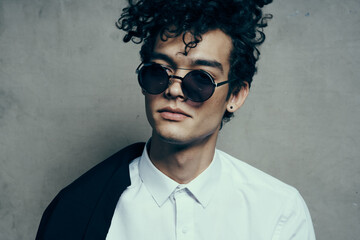 Obraz premium handsome guy model in shirt and glasses jacket on shoulder portrait close-up