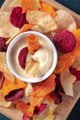 Colorful vegetable chips with a homemade dip close-up