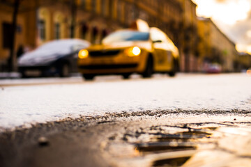Bright winter sun in a big city, the taxi rides on the street. Close up view of a hatch at the...