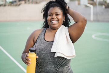 Curvy african girl doing workout morning routine outdoor at city park - Plus size person and sport...