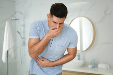 Man suffering from nausea in bathroom. Food poisoning