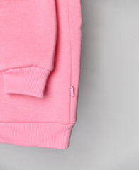 Close up of baby pink sweatshirt hoodie with label.