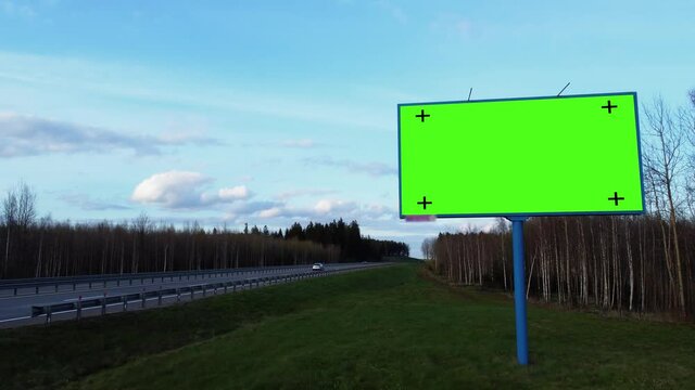 Mock up concept to place your image, logo, slogan. Billboard poster with green screen and tracking markers on a highway. 
