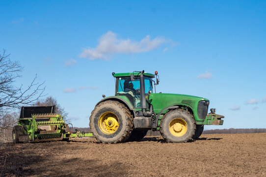 Spring plowing. Agricultural work in the fields. A tractor plowing the land. Soil fertilization. Kaliningrad region, Russia, April 4, 2021. 
