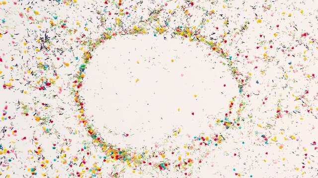 The hand makes a round frame for the inscription in the background of baking sprinkles. Time lapse video, 16x9 format. ProRes 422 HQ.