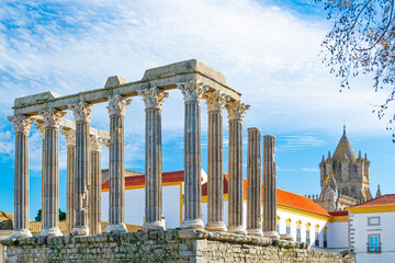 Roman temple of Évora and cathedral in the background in a sunny day with blue Sky.