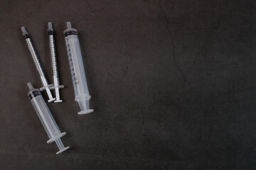 The syringe is commonly used by hospitals on a black background.