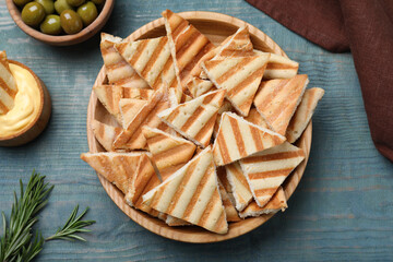 Delicious pita chips on blue wooden table, flat lay