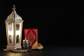 Composition with Arabic lantern and quran on black table. Space for text