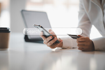 Close up woman hand using credit card and smartphone laptop for buying online shopping and search