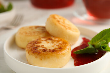 Delicious cottage cheese pancakes with jam and mint on table, closeup