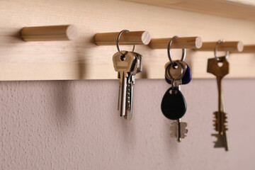 Wooden hanger for keys on color wall, closeup