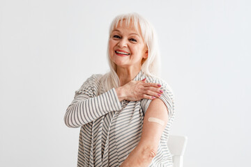 Smiling Mature Woman Showing Vaccinated Arm After Antiviral Injection - obrazy, fototapety, plakaty