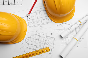 Flat lay composition with blueprints and hardhats on white background