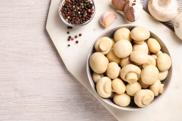 Tasty marinated mushrooms, garlic and pepper on white wooden table, flat lay. Space for text