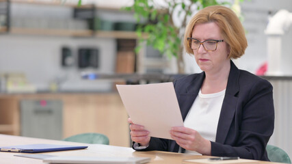 Senior Old Businesswoman Reading Documents at Work