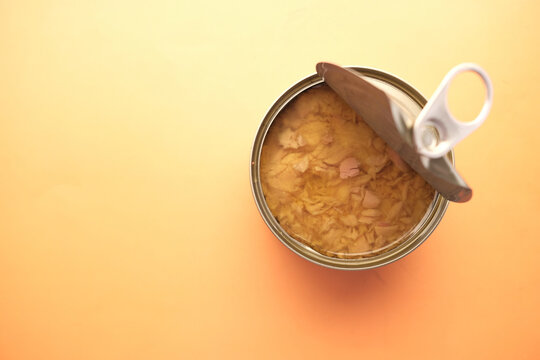 canned tuna on orange background close up 