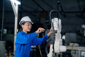 Woman mechanic repairing a robot machine.