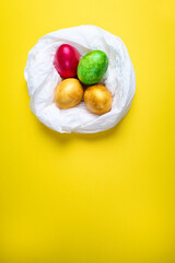 Colored eggs into a nest on a multicolored background .