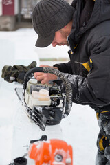 Portrait of a worker repairing a gasoline saw