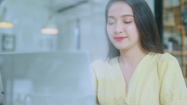 young attractive asian female wear casual cloth hand use smartphone and laptop device comminication social contact in cafe restaruant sit at counter next to big window daylight