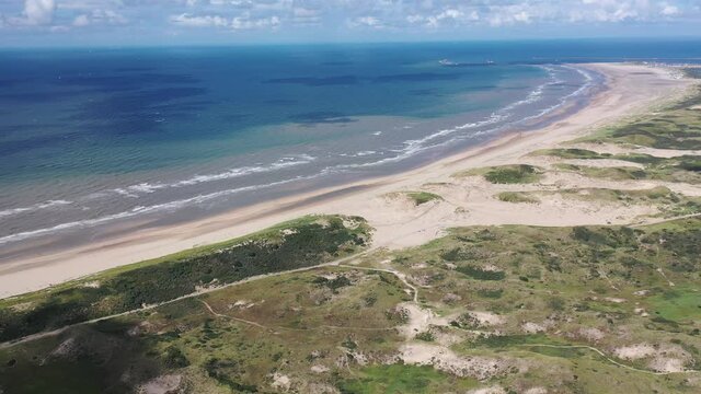Aerial view of sea waves and sandy beach above the beach of zandvoort netherlands.