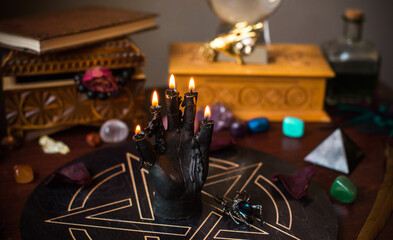 A fortune teller, witch stuff on a table, candles and fortune-telling objects. The concept of divination, astrology and esotericism