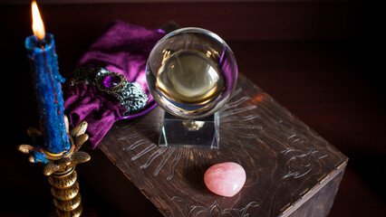 A fortune teller, witch stuff on a table, candles and fortune-telling objects. The concept of divination, astrology and esotericism