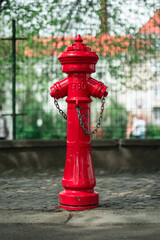 An old red fire hydrant from 1930 on a city street.