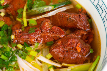 cooked beef with green onions, in cooked broth, served with greenery