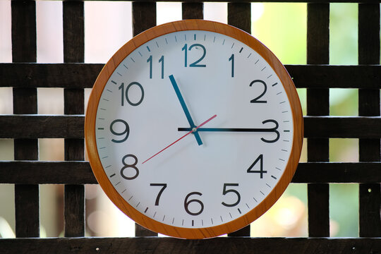 Wall clock on wood background and time concept