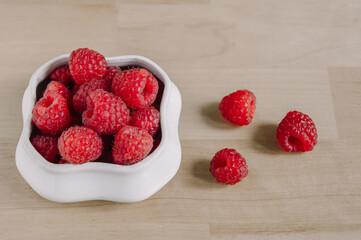 fresh raspberries in a small white bowl.