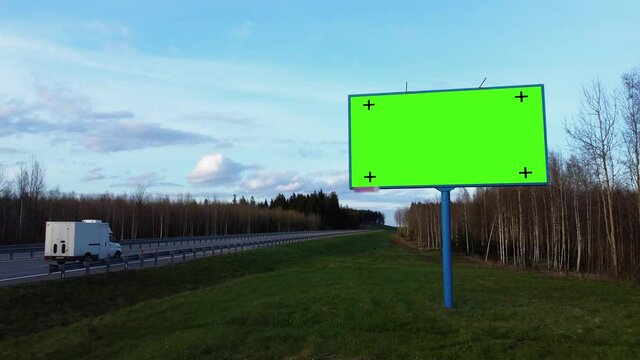 Mock up concept to place your image, logo, slogan. Billboard poster with green screen and tracking markers on a highway.